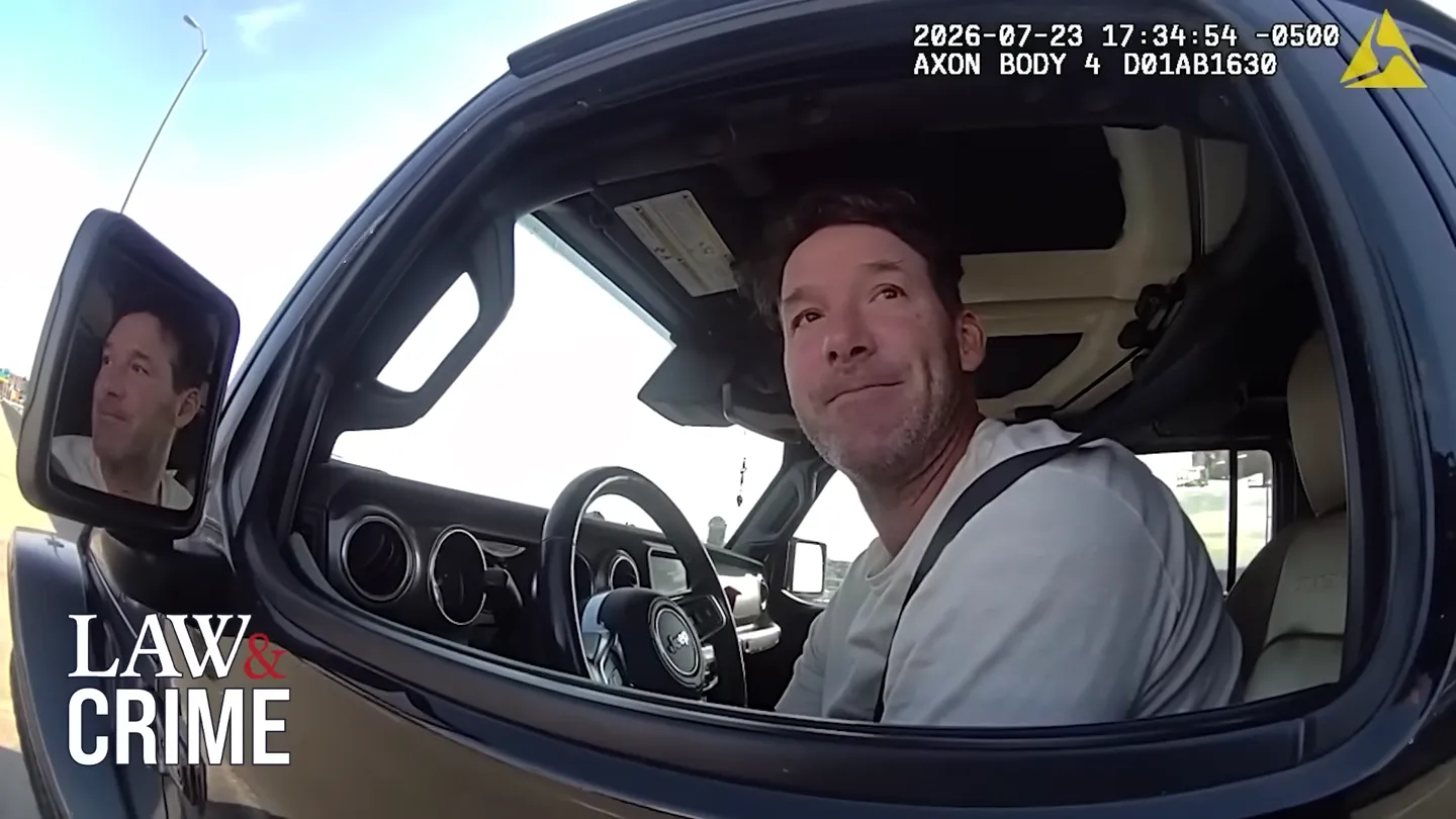 Tony Romo seated in his Jeep during the Milwaukee County traffic stop, looking up at the deputy, in Axon body-camera footage timestamped July 23, 2026